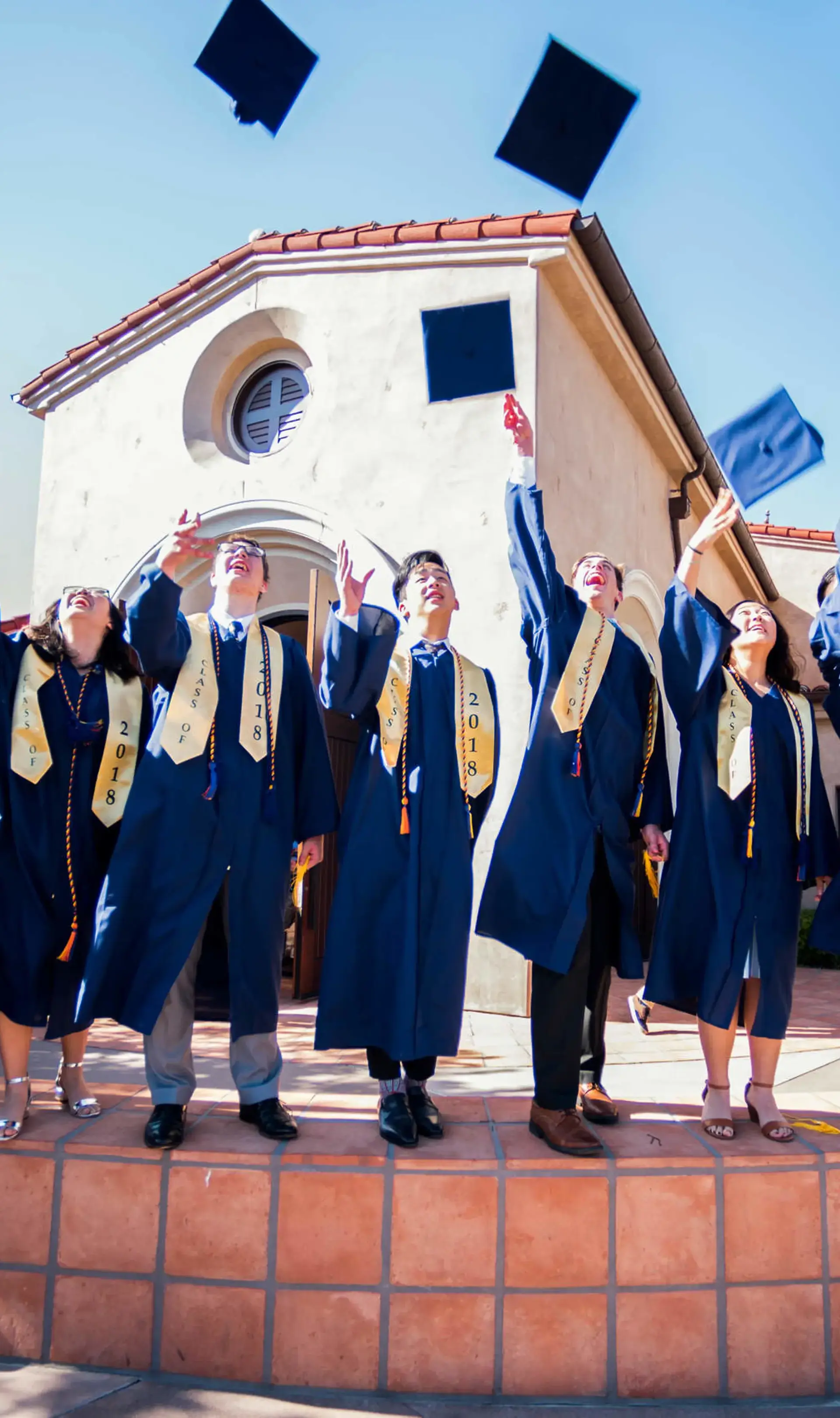 Members of The Cambridge School's first graduating class in 2018 joyfully toss their caps in the air, celebrating a classical Christian education rooted in truth, goodness, and beauty.