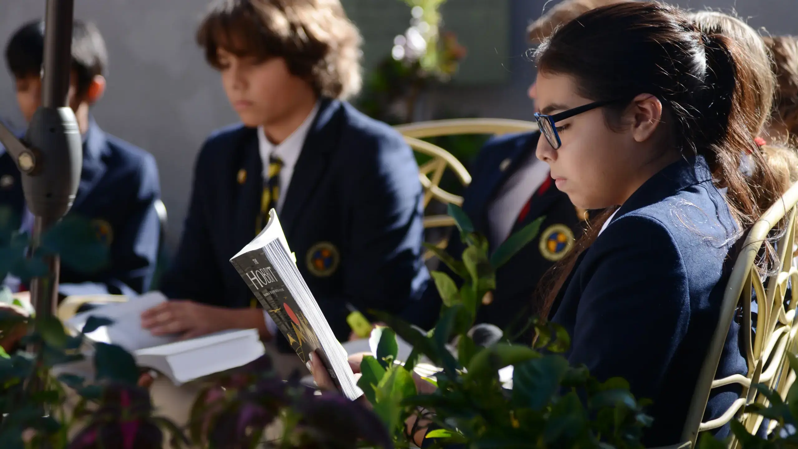 Cambridge School upper school students in uniform read classical literature outdoors during a morning lesson — highlighting a classically educated approach at one of the best private Christian schools