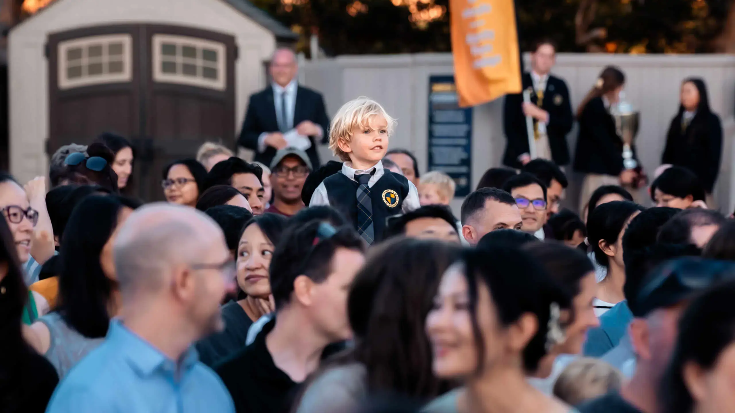 Grammar school boy recognized during a Cambridge School event, surrounded by parents and peers at this San Diego classical Christian school.