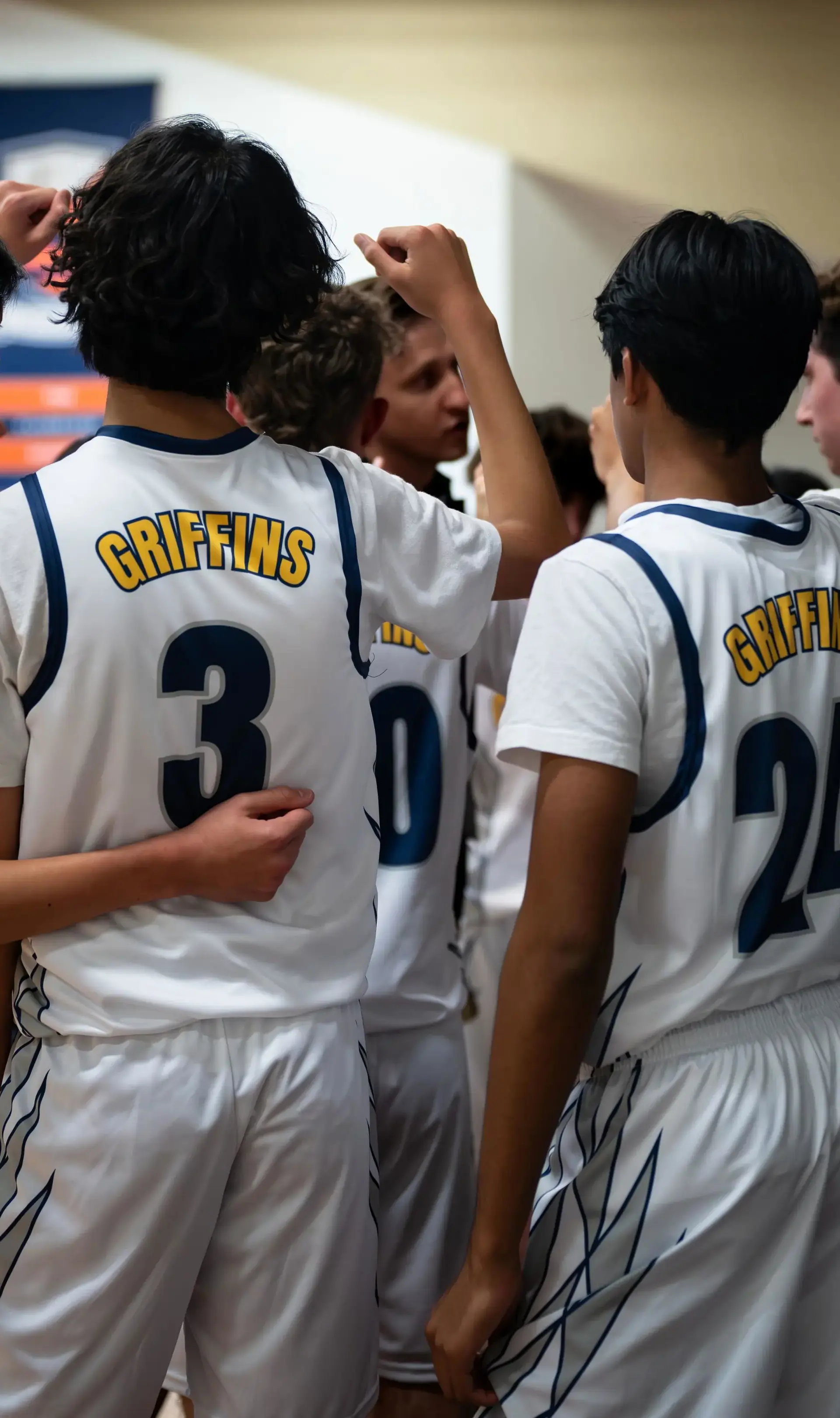Student athletes in huddle on basketball court