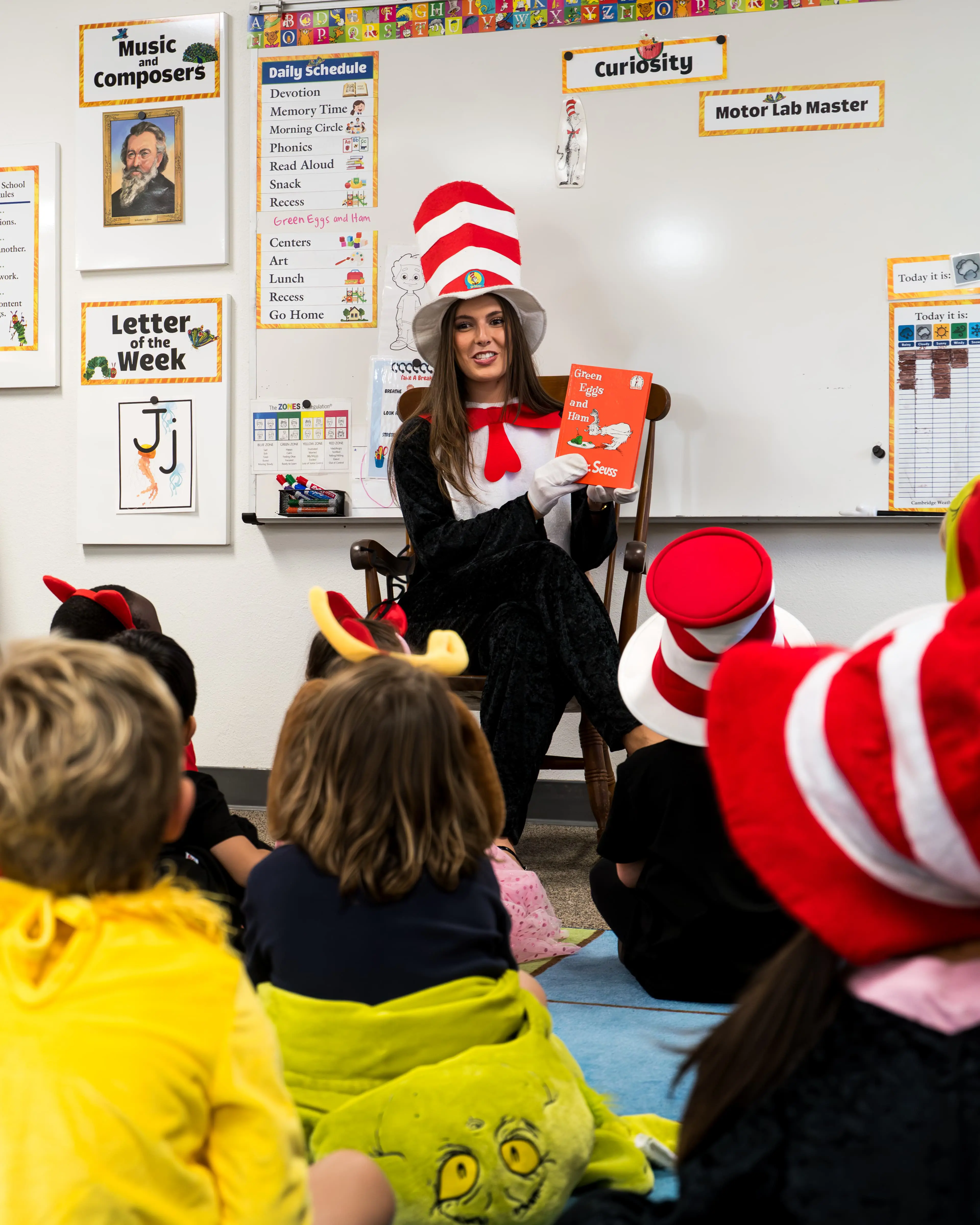 teacher dressed up as cat in the hat reading to young students