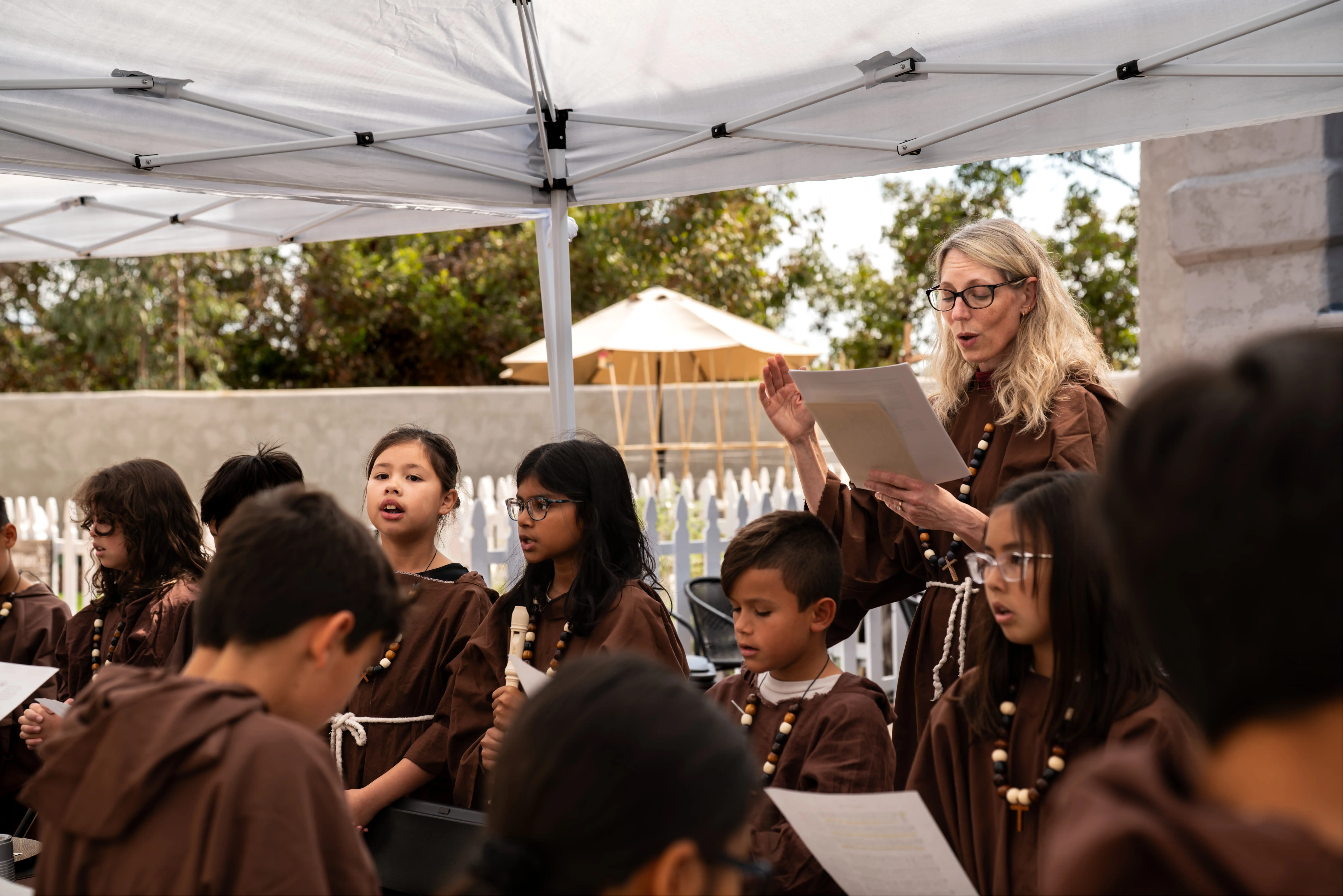 Latin teacher reciting latin as students embody monks during monastery day