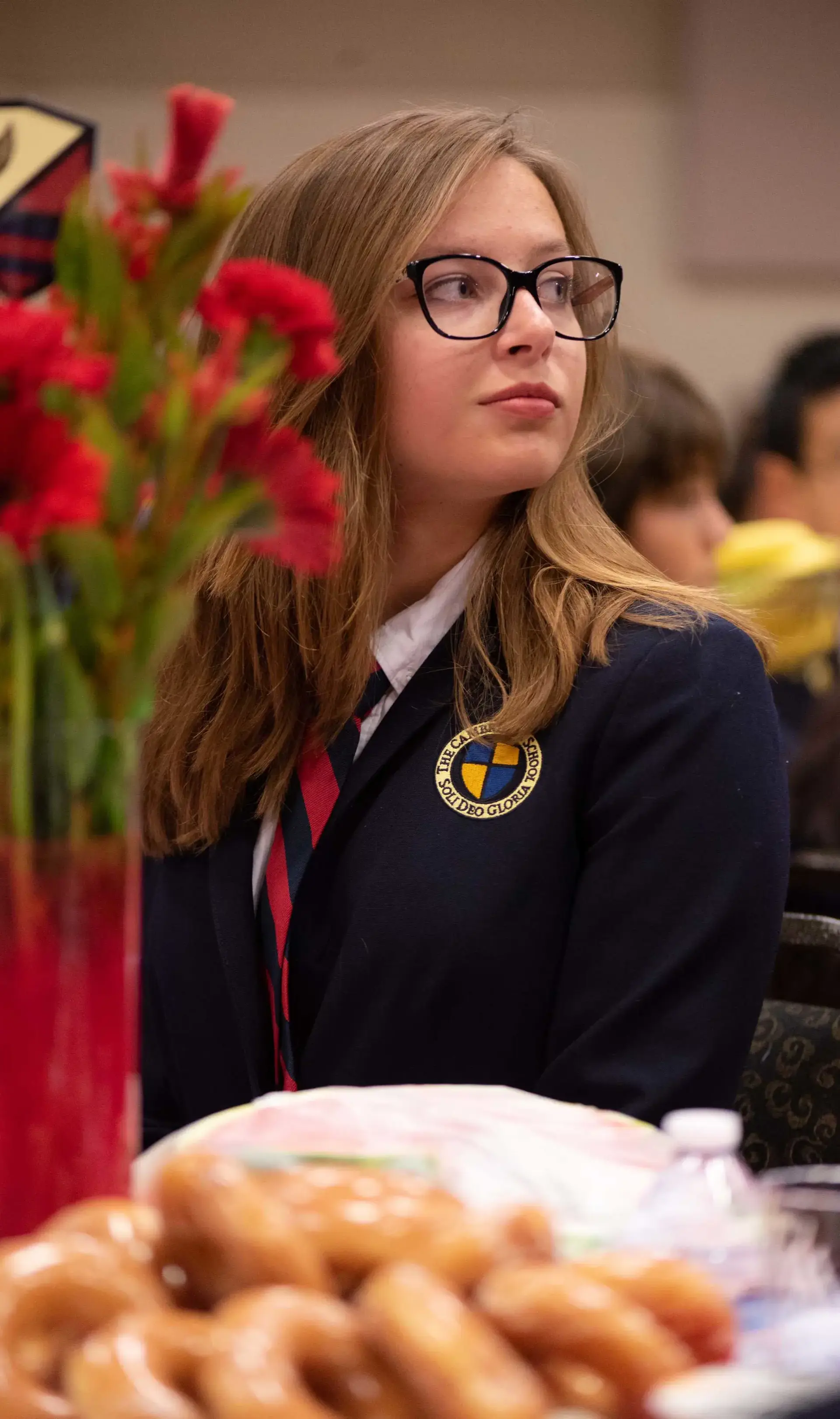 Student sitting at dinner table listening to convocation speech