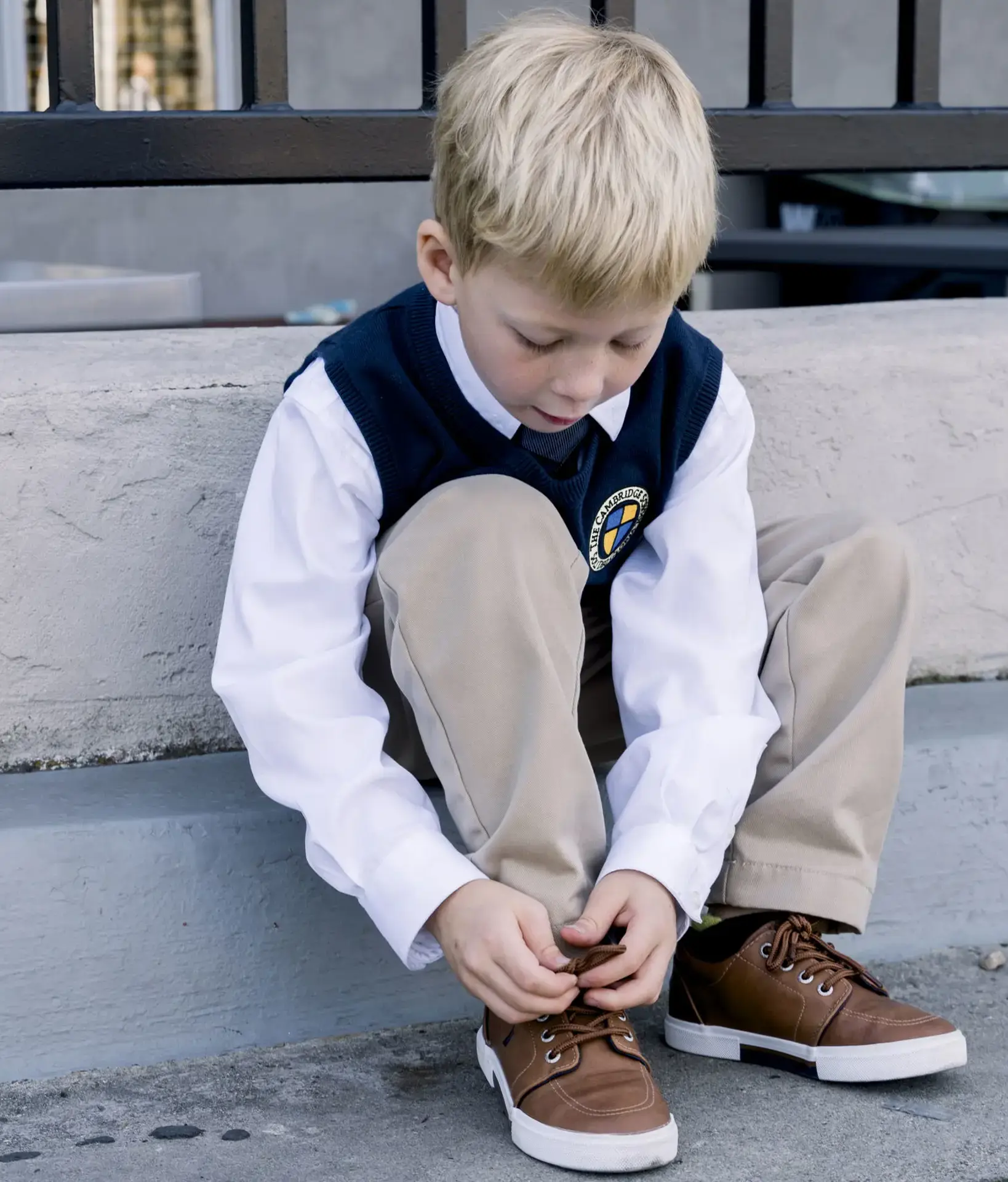 Student sitting on steps tying their shoelaces
