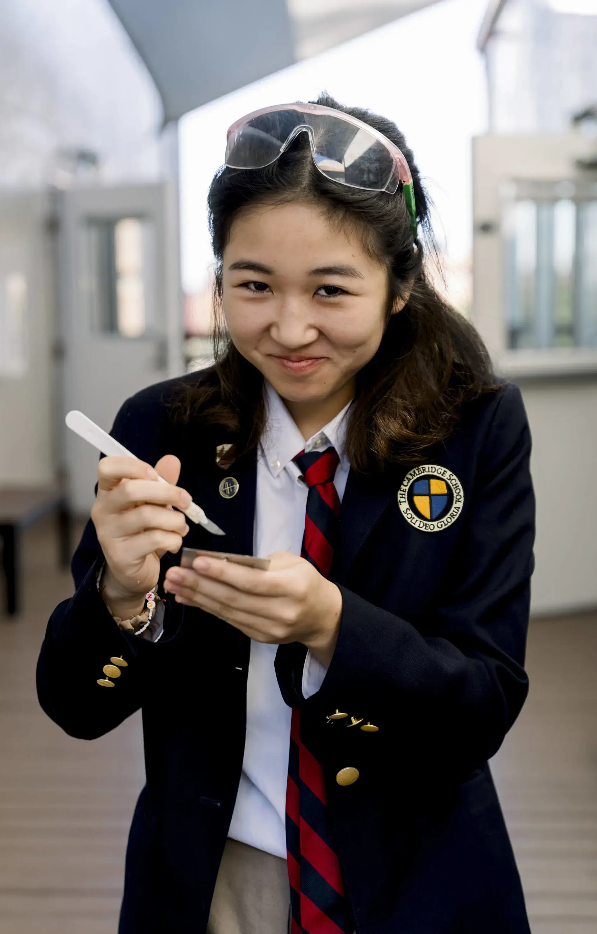 Student with goggles on their head smiling at camera