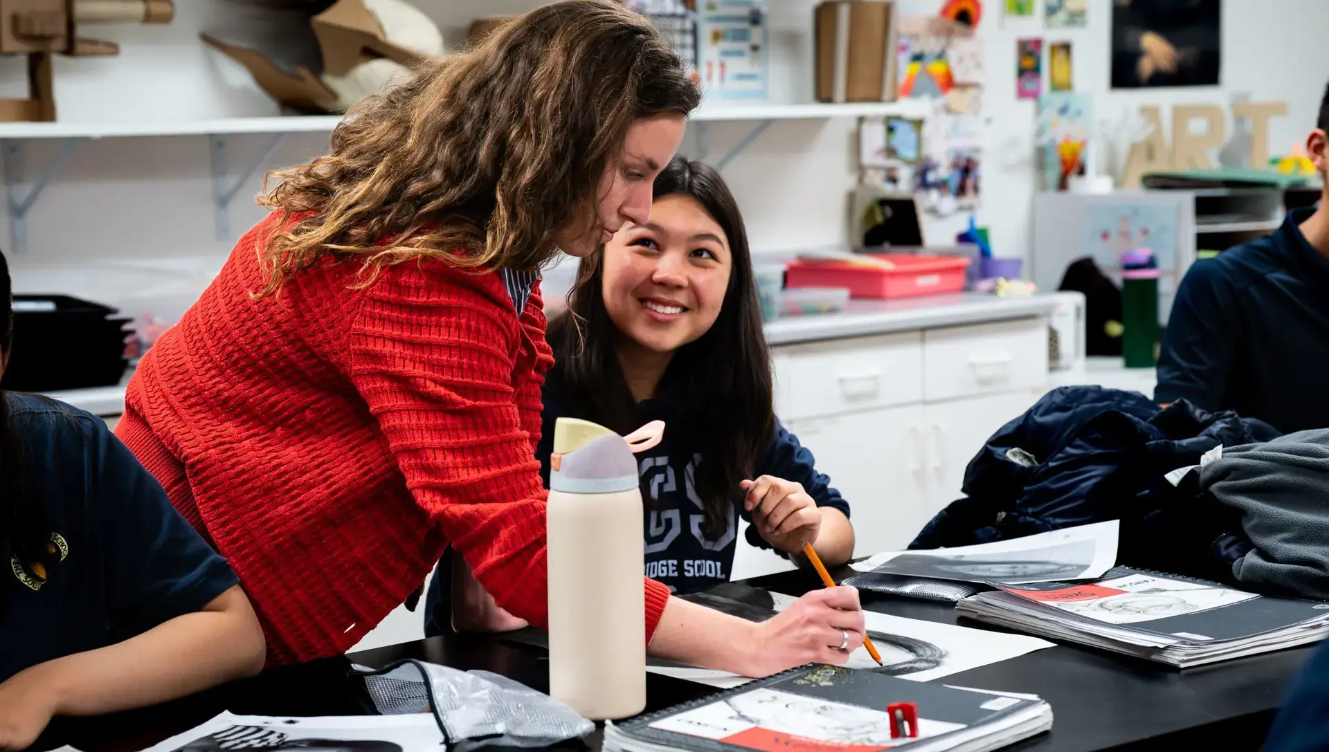 Teacher assisting student with work in classroom