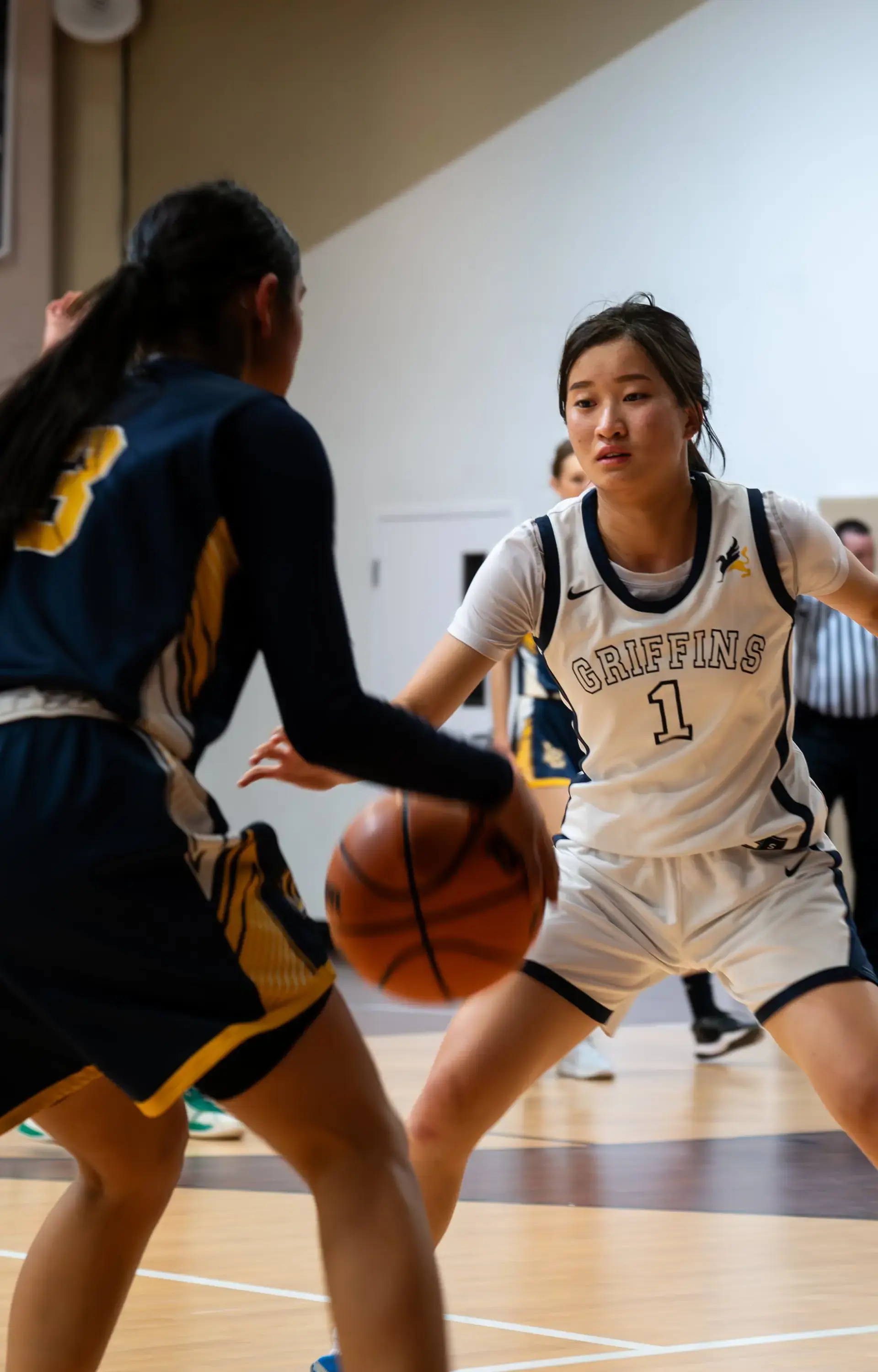 A Cambridge Griffins player defends during a varsity basketball game — showcasing the discipline, teamwork, and perseverance fostered through athletics at The Cambridge School.