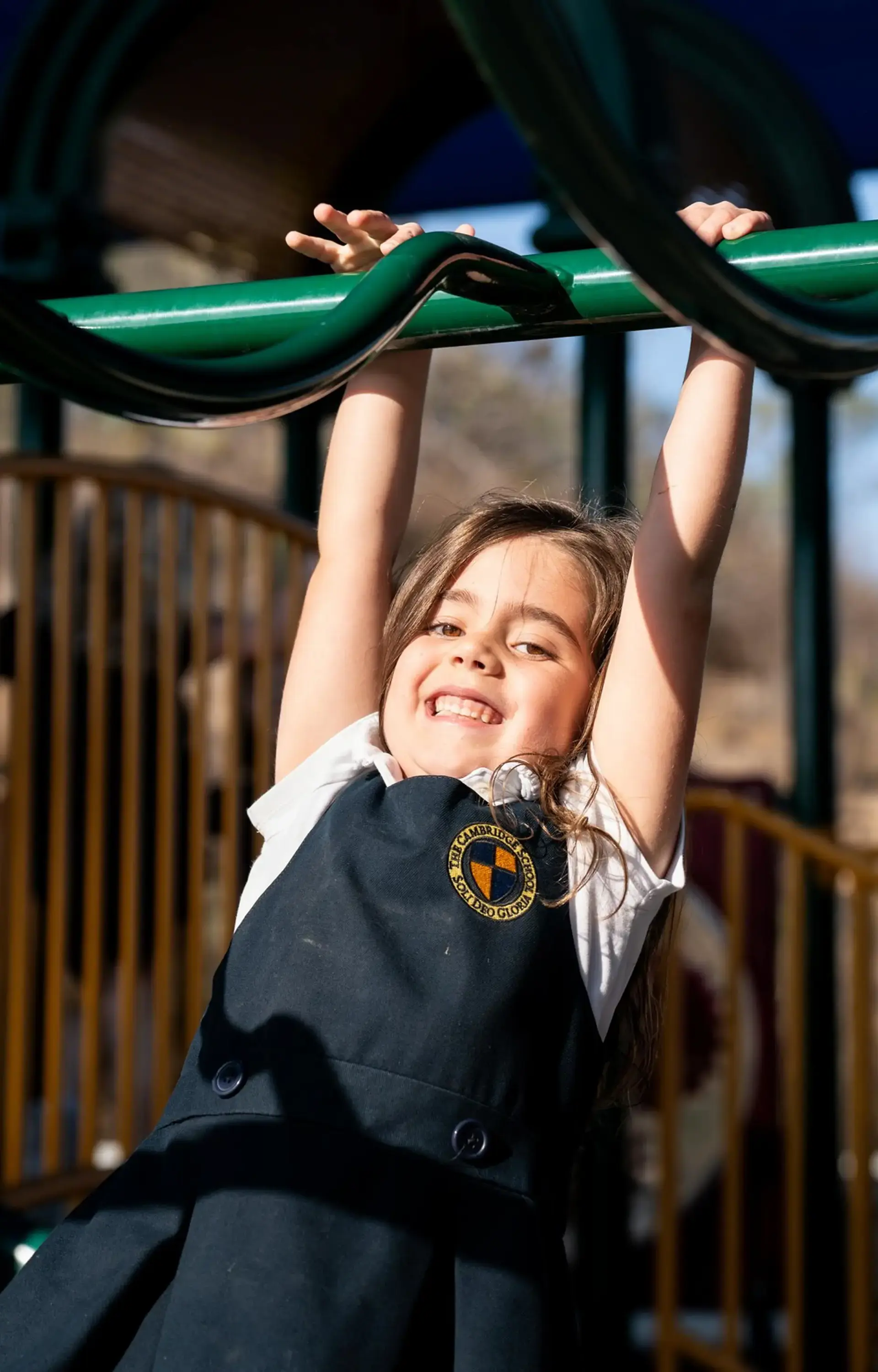 Student hanging from playground equipment