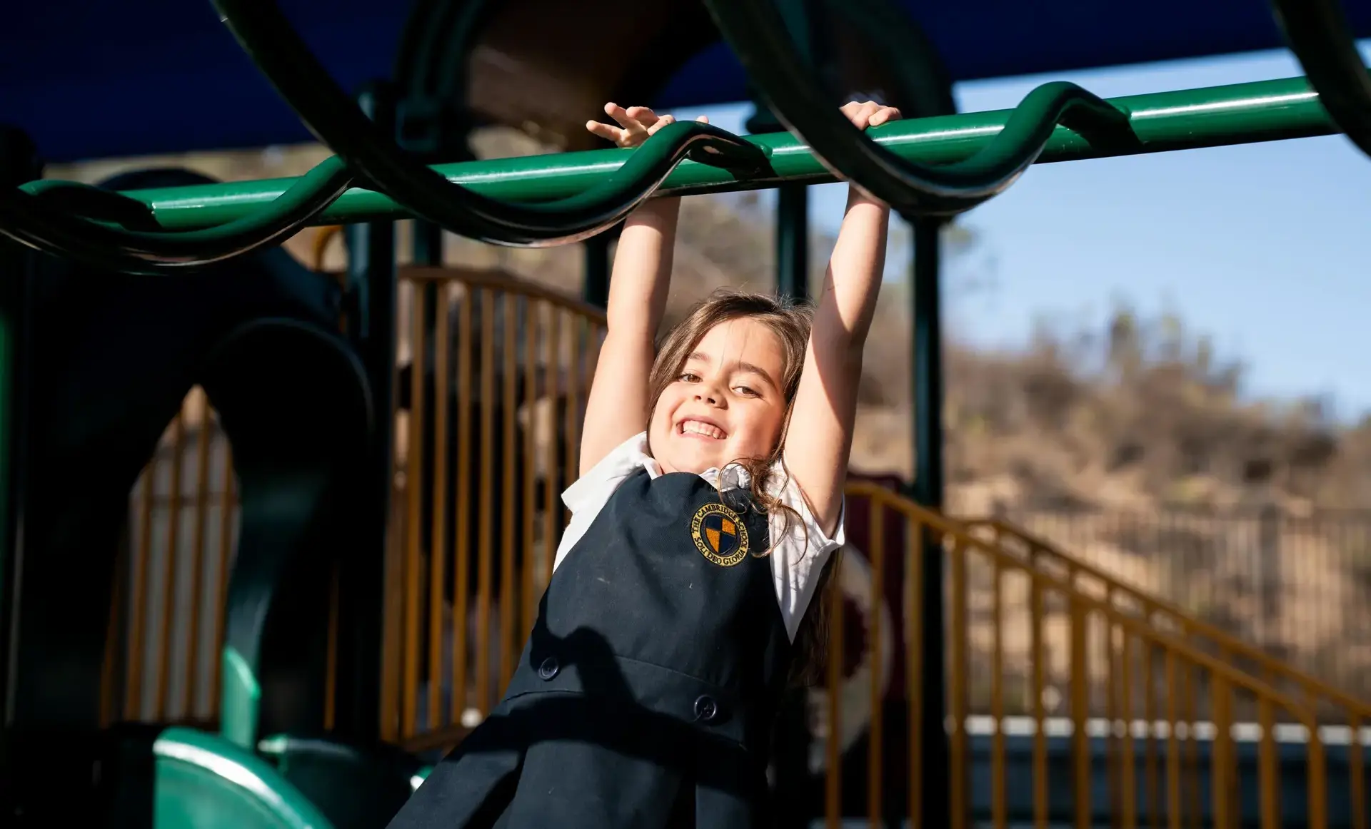 Student hanging from playground equipment