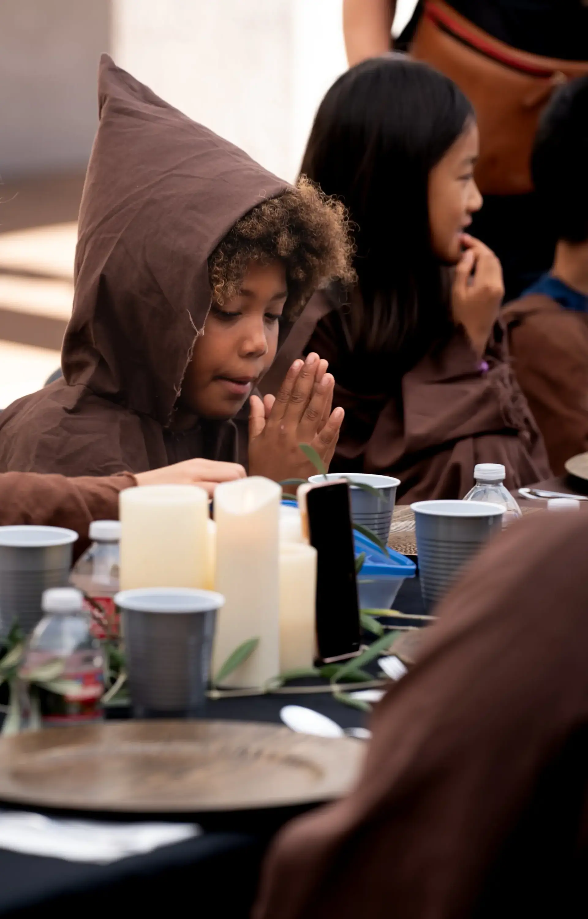 Student in costume praying at table