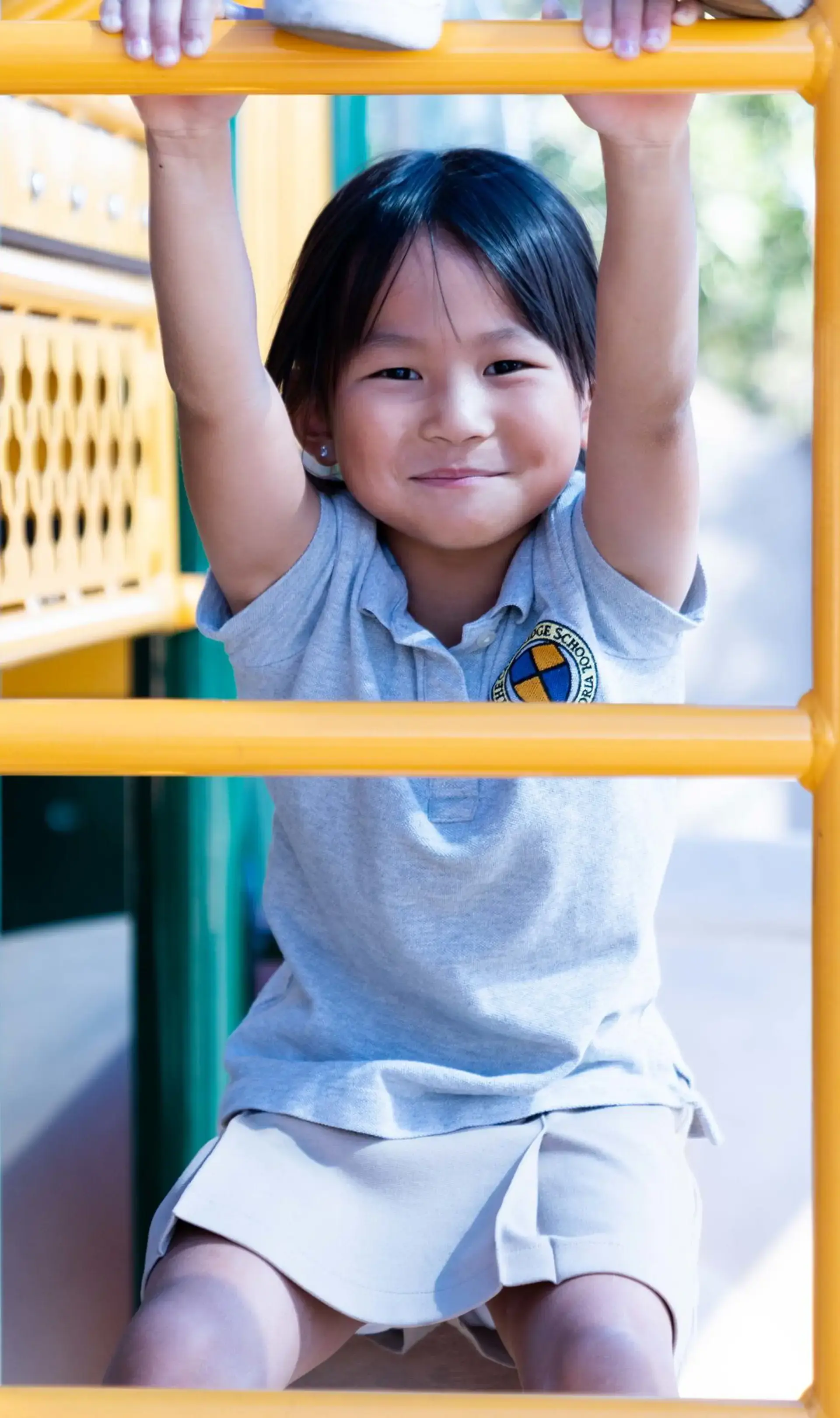 Kindergartner climbing up yellow ladder