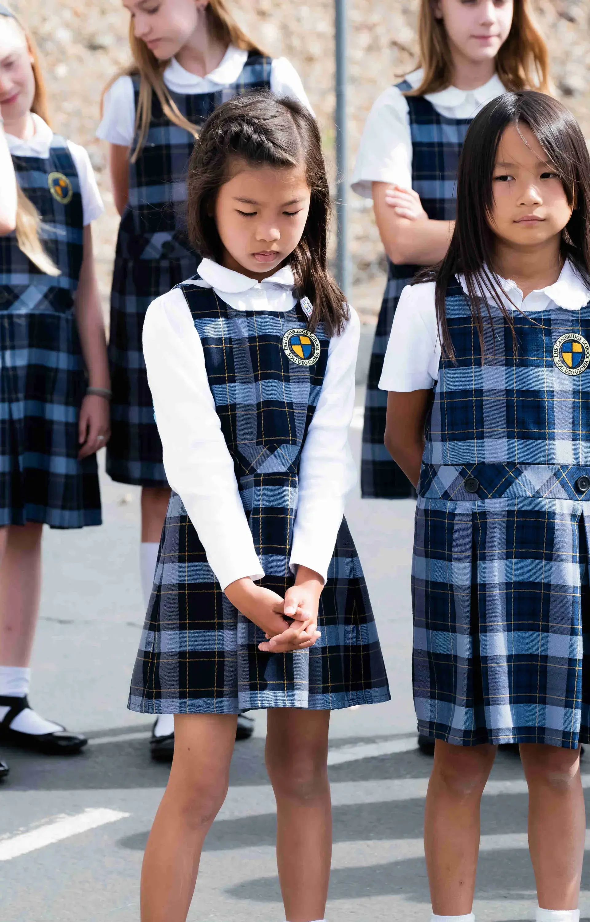 Students at closing convocation, one with their hands clasped and head bowed in prayer