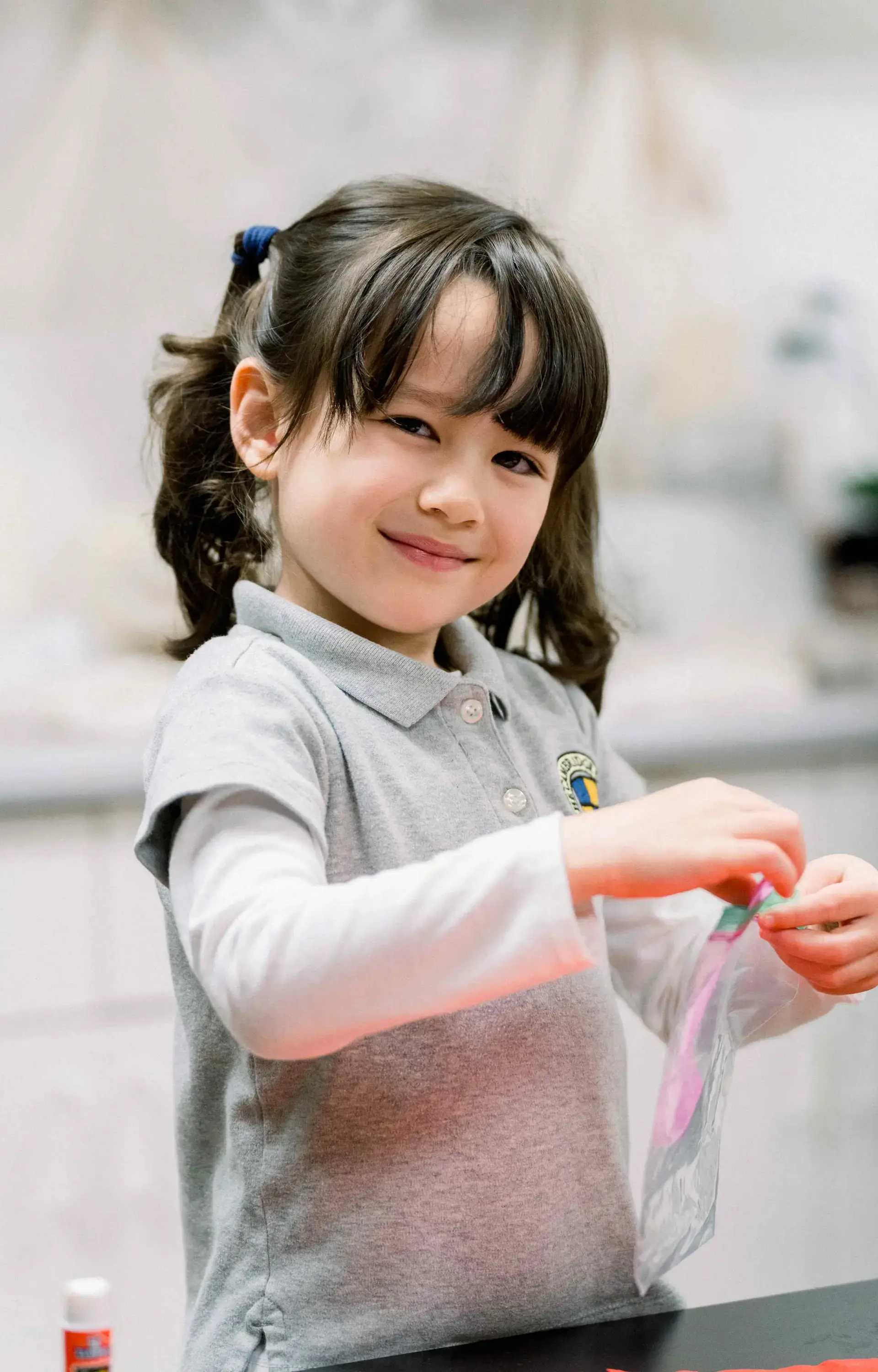 Smiling student holding craft supplies
