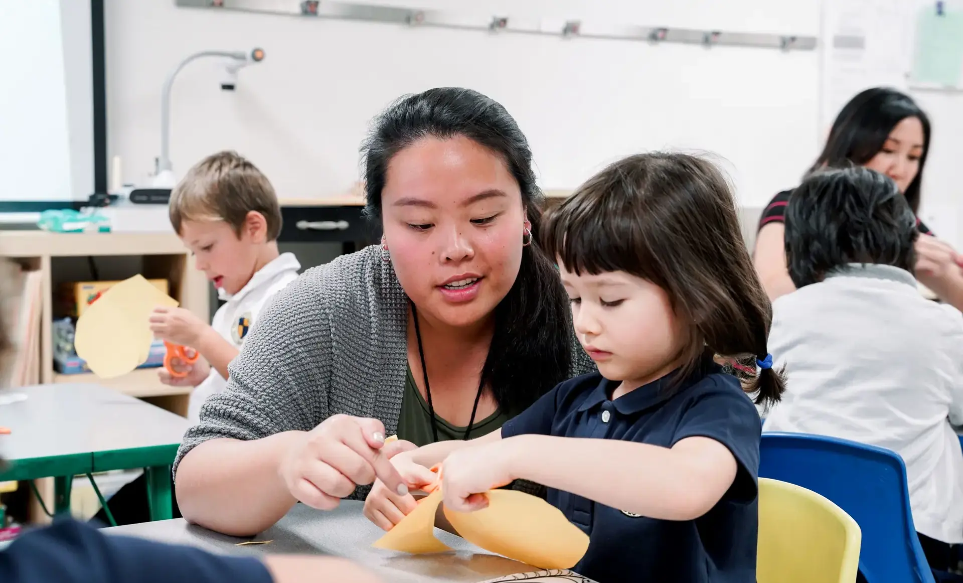 Student and teaching doing craft project together