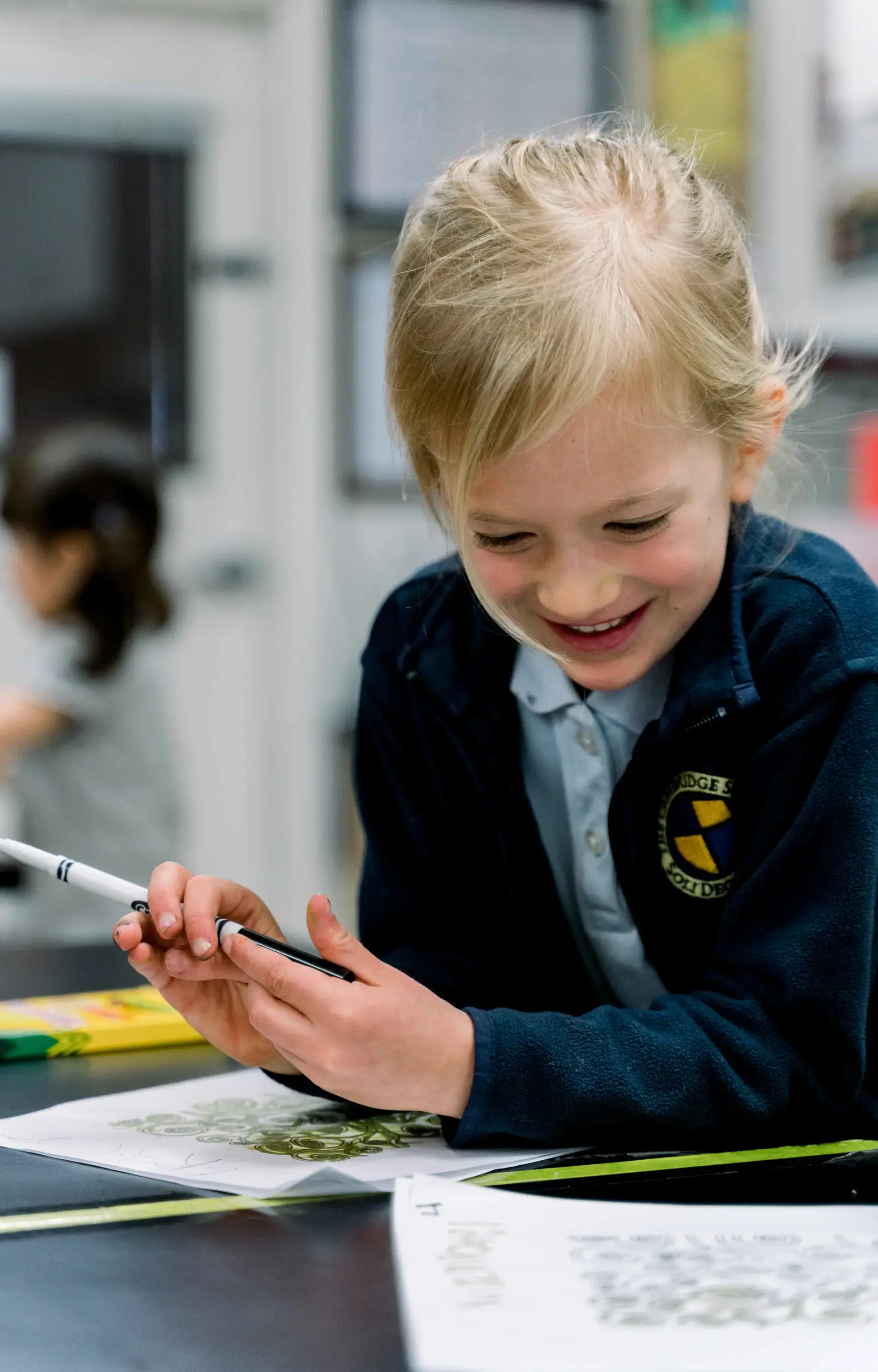Student smiling while taking down notes in lesson.