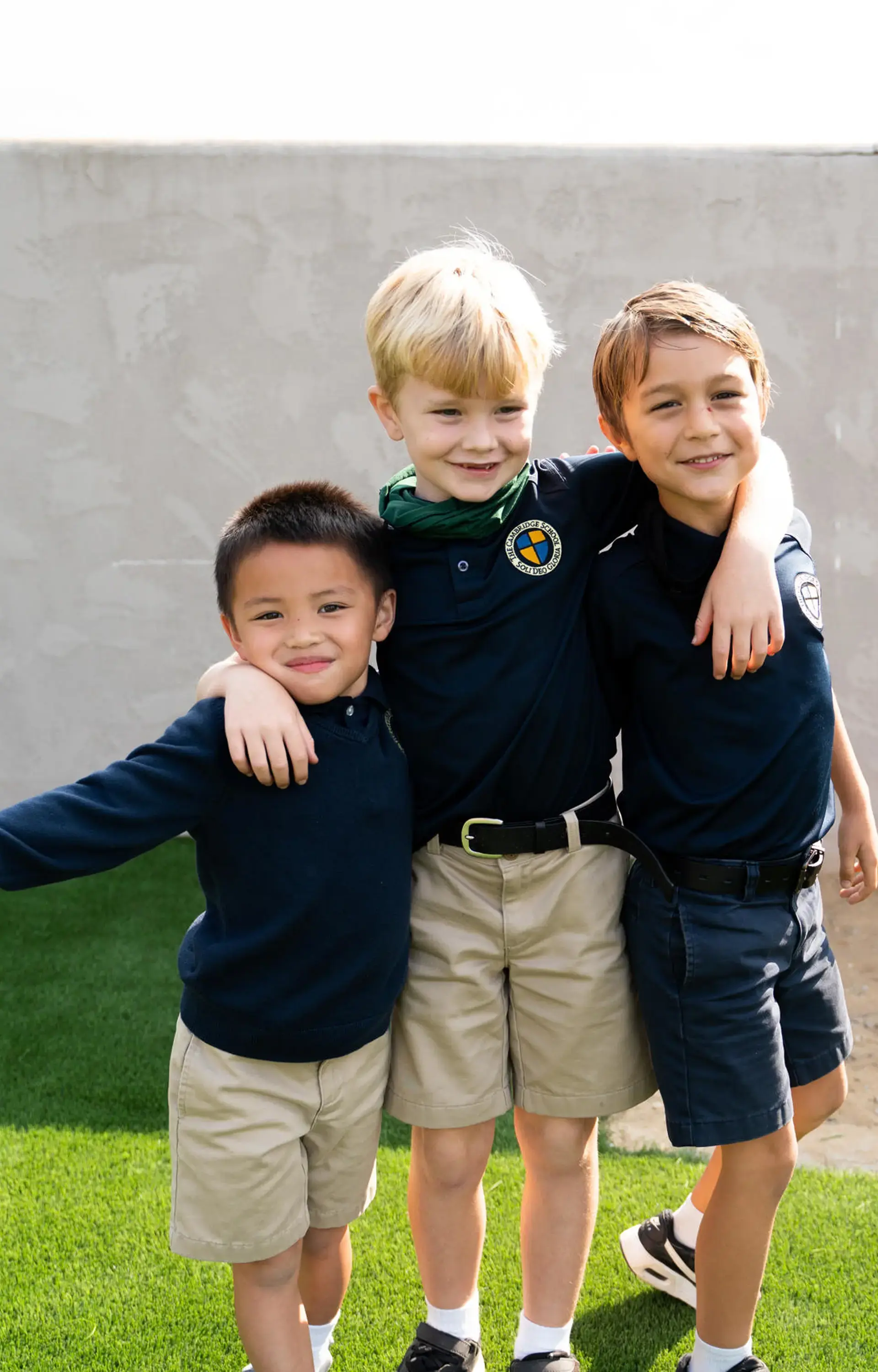 Three students smiling together on the playground