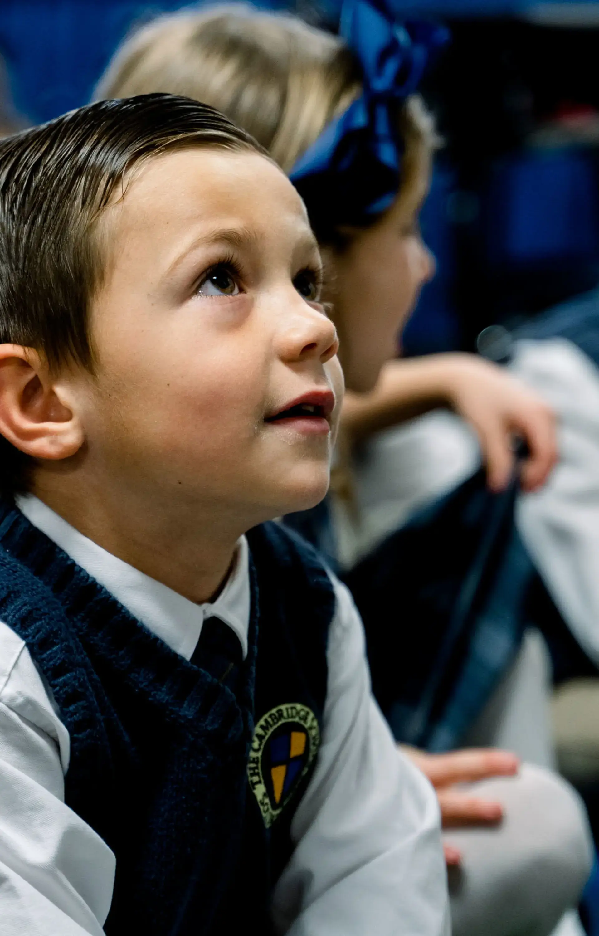 Young student at The Cambridge School listens attentively during a classroom lesson, exemplifying the focus and engagement fostered by private Christian schools in San Diego.