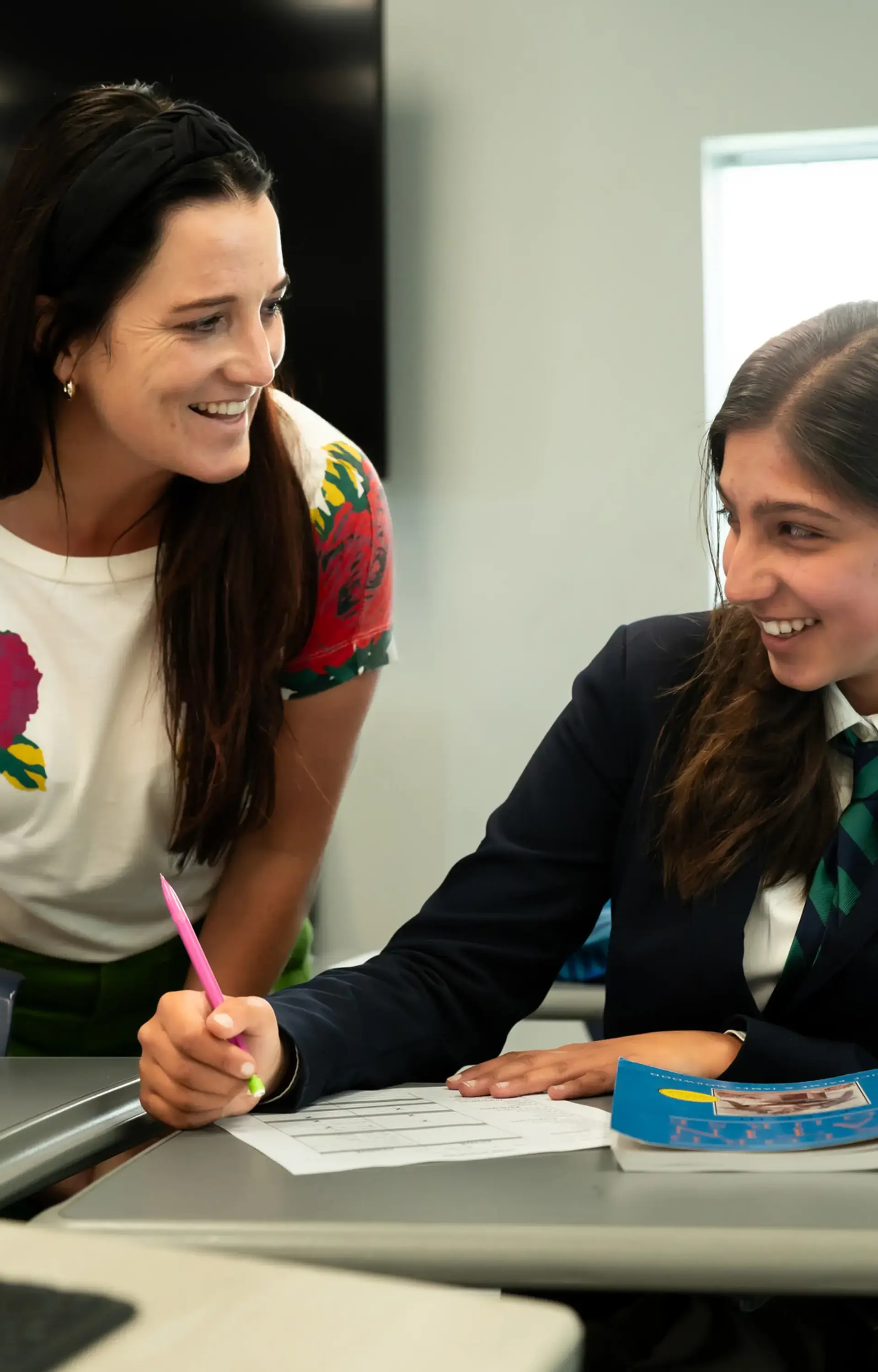 A teacher and upper school student at The Cambridge School, a private Christian school in San Diego, share a moment of joyful collaboration.