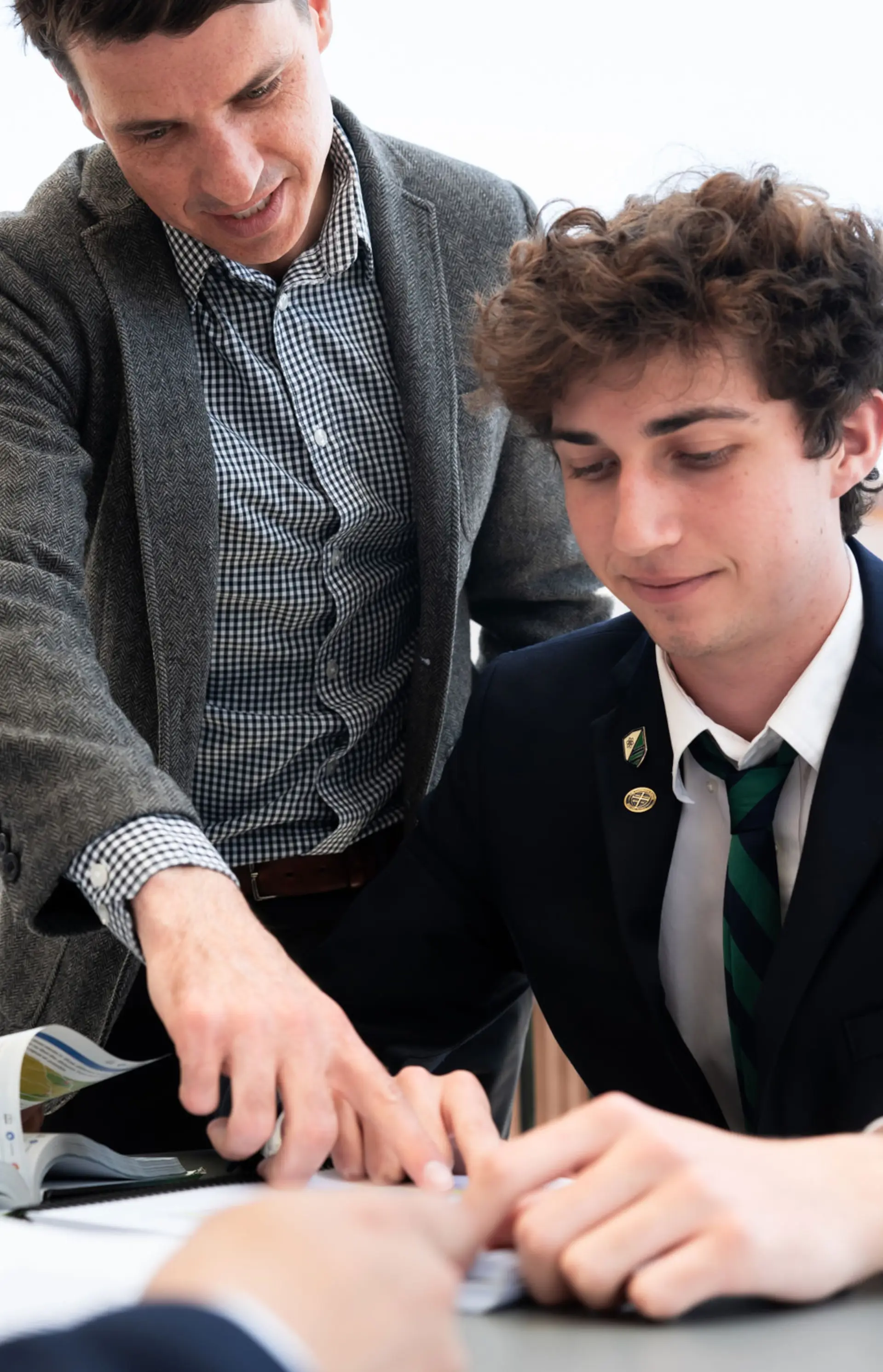 Teacher mentors two upper school students in dress uniform at The Cambridge School, a private Christian school in San Diego.