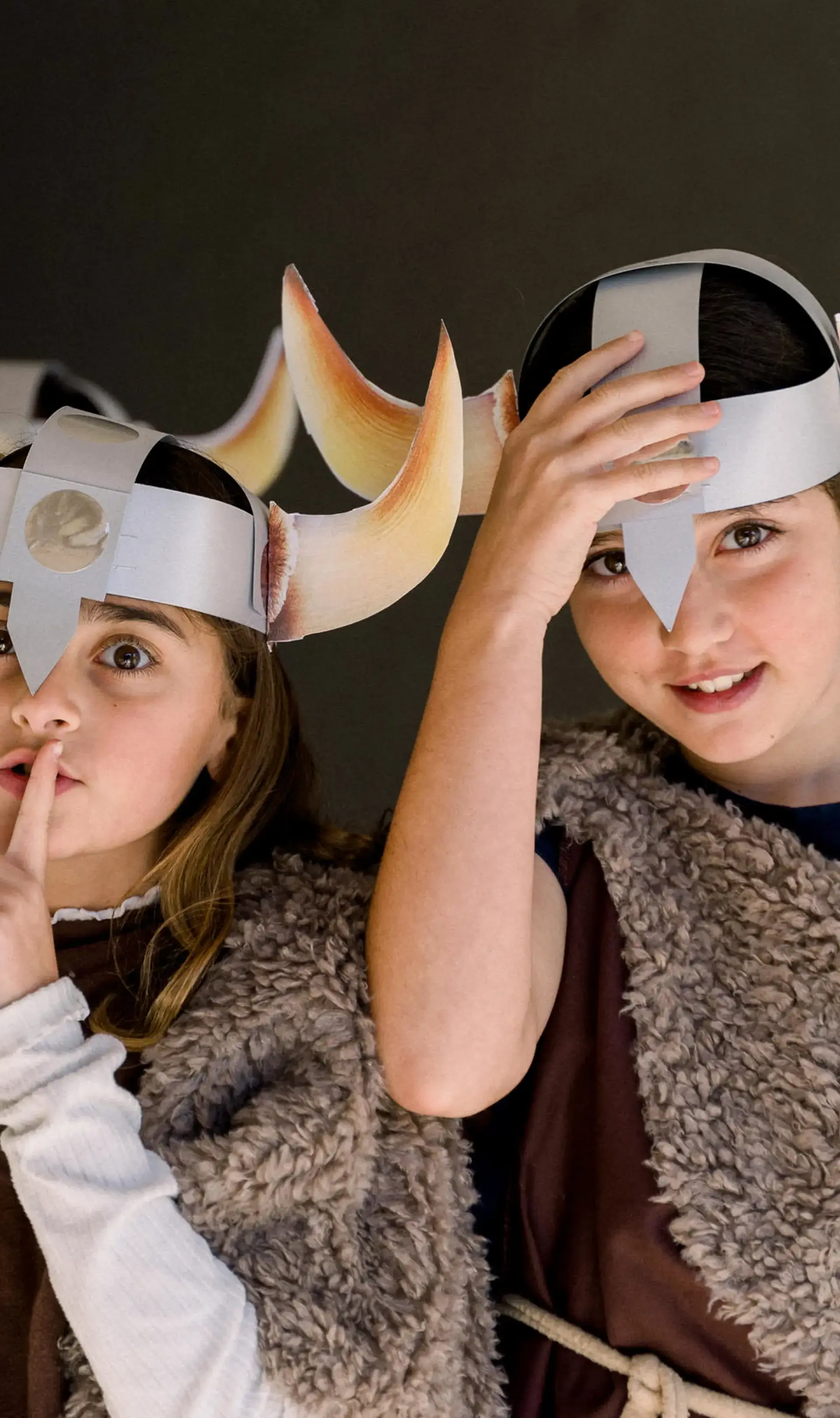 Two students dressed as vikings, one shushing and the other tilting their helmet