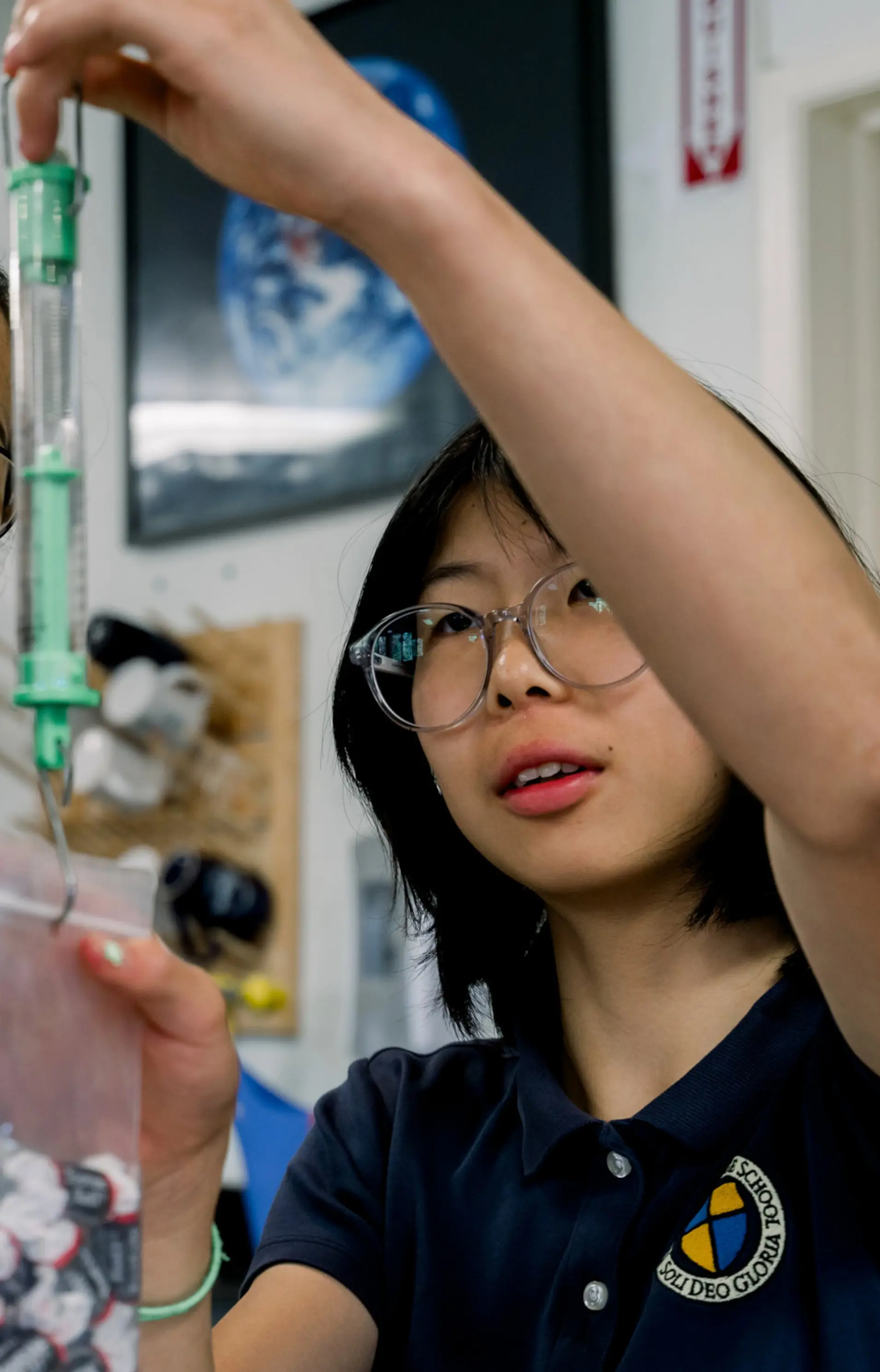 A Cambridge School science teacher mentors students during a hands-on biology lab, fostering curiosity and critical thinking in a classical Christian school setting in San Diego.