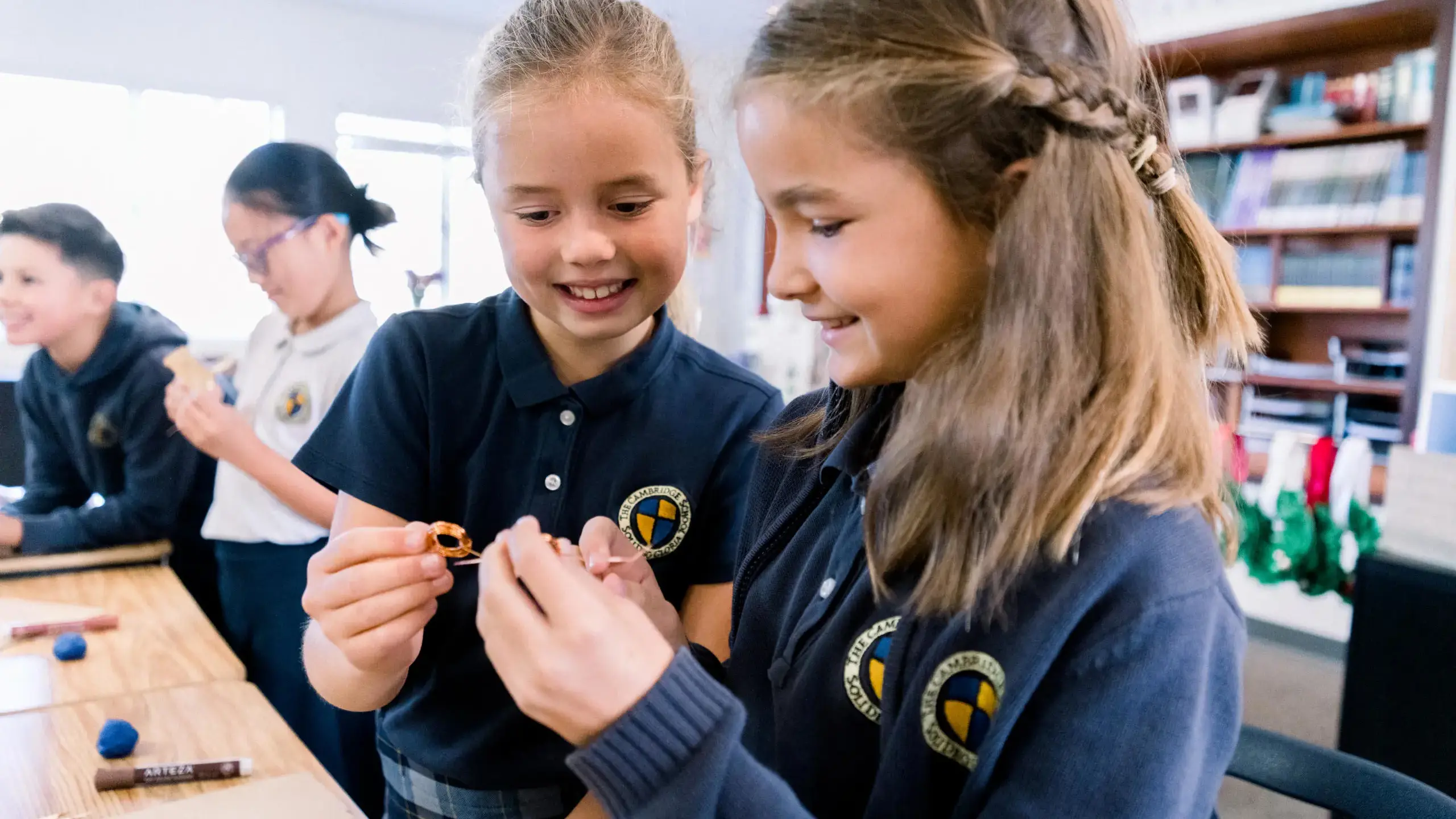 Two Cambridge School elementary students collaboratively engage in a hands-on project in a classroom.