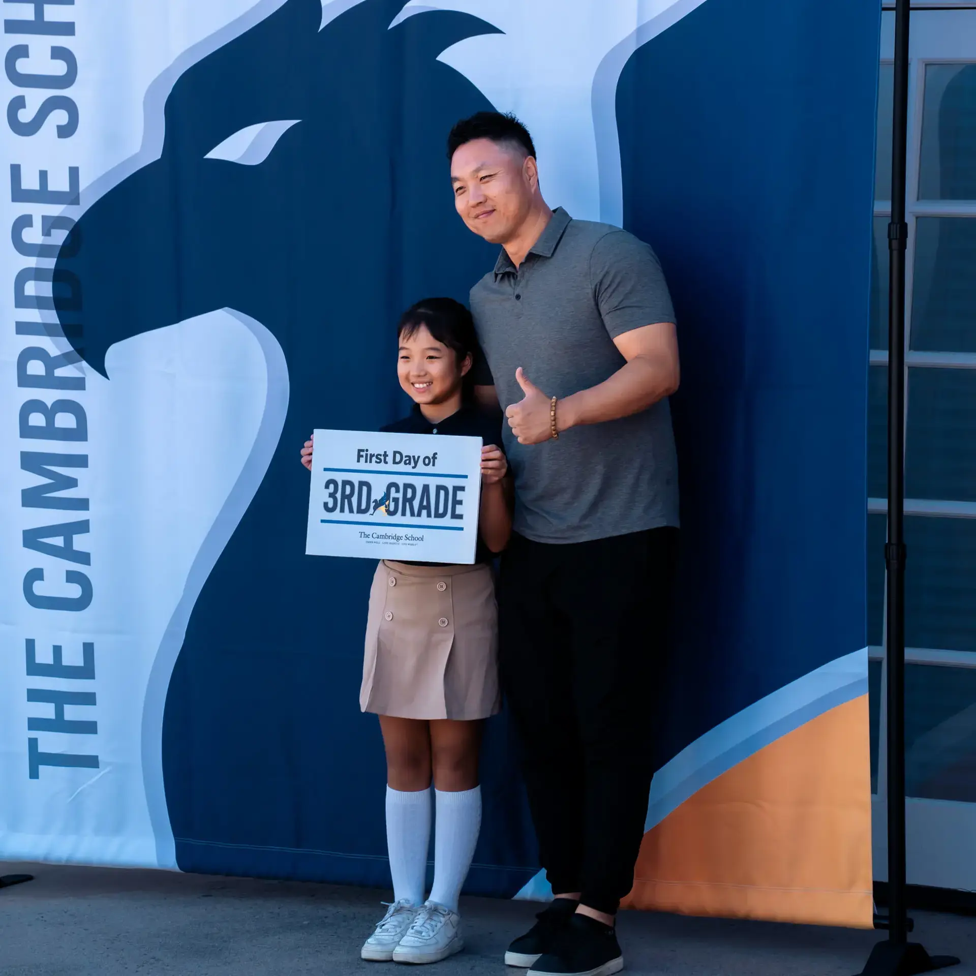 Father and daughter pose for a first day of third grade photo at The Cambridge School, a private Christian school in San Diego known for its classical education and welcoming community.
