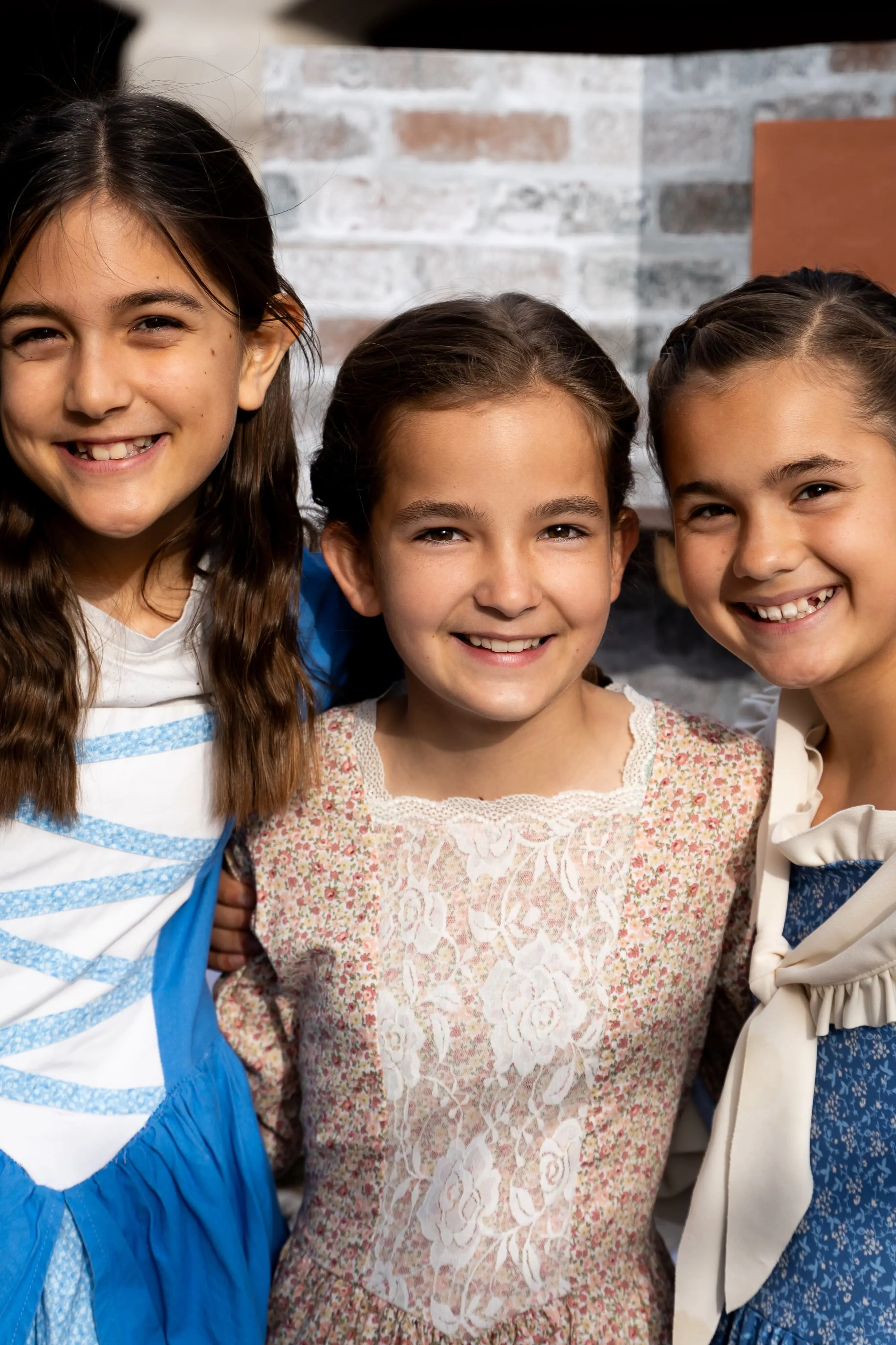 three grammar school students dressed in colonial garb celebrating the culmination of their studies on colonial America.