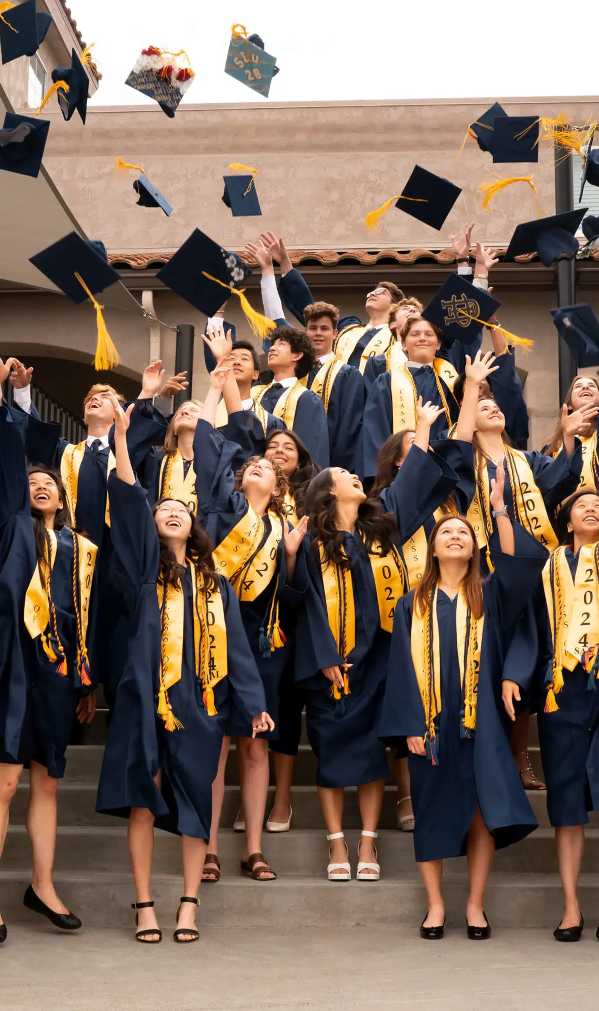 Graduating seniors at The Cambridge School celebrate by tossing their caps in the air, marking the culmination of a classically educated journey at one of the best private high schools in San Diego.
