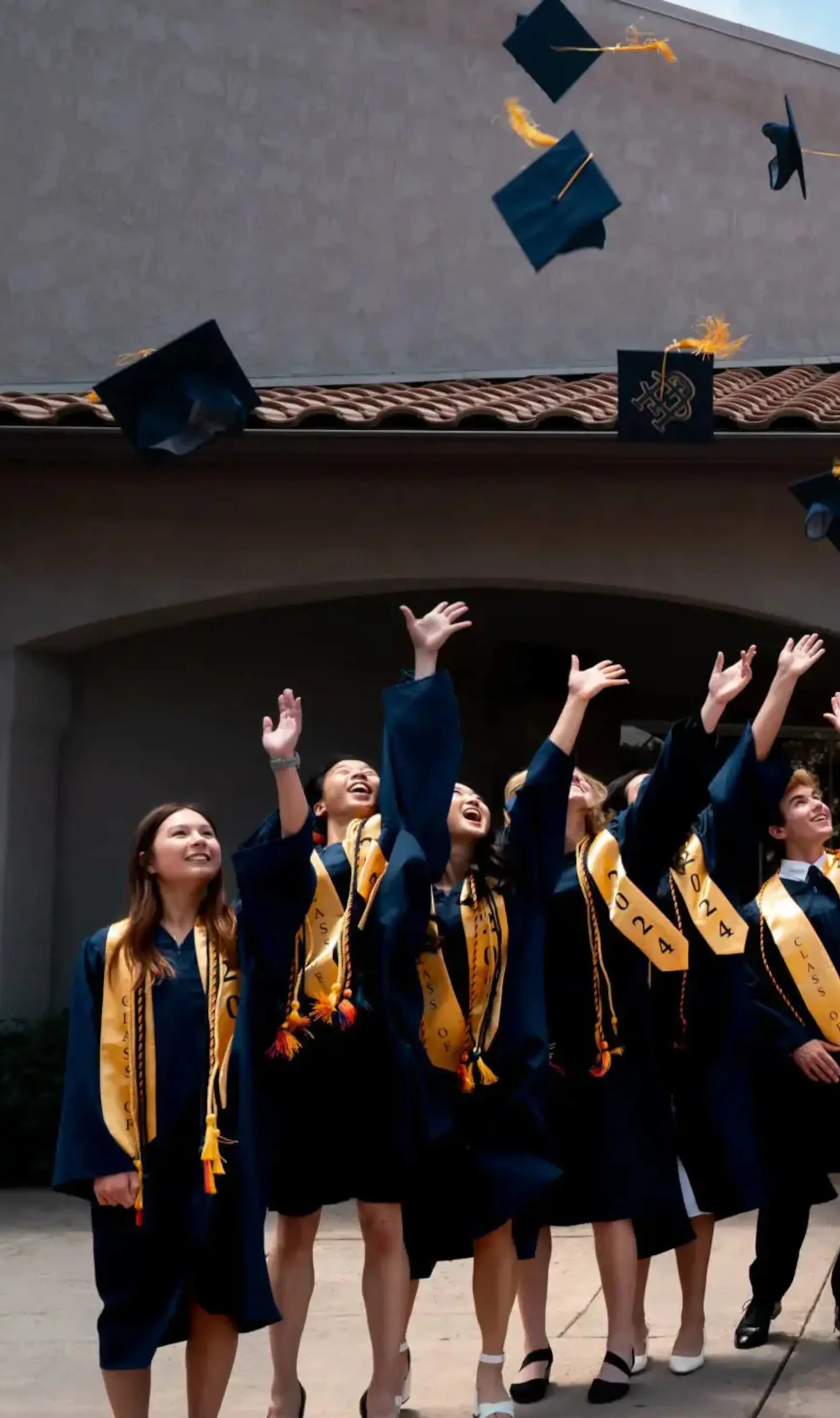 Students throwing graduation caps in air