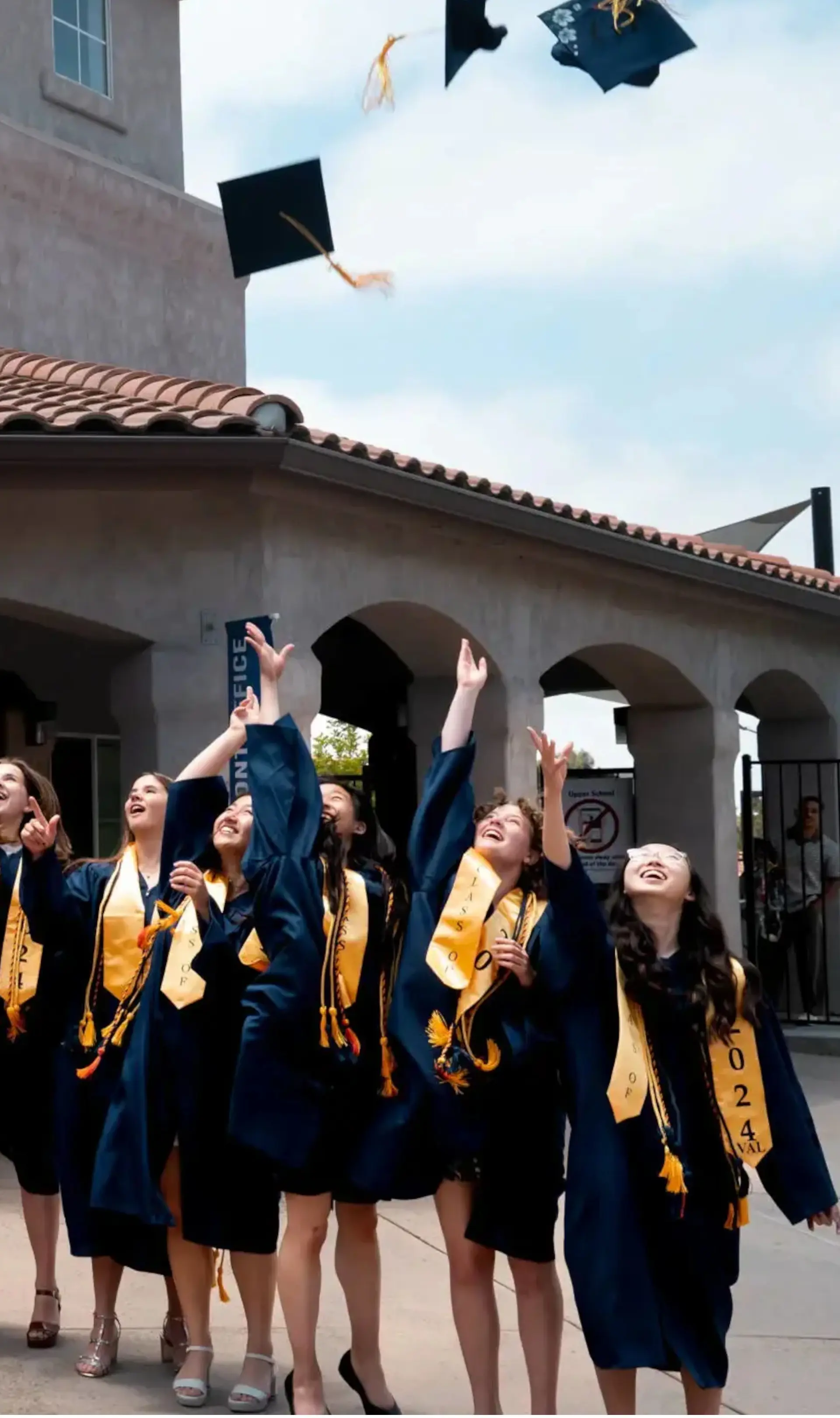 Students throwing graduation caps in air