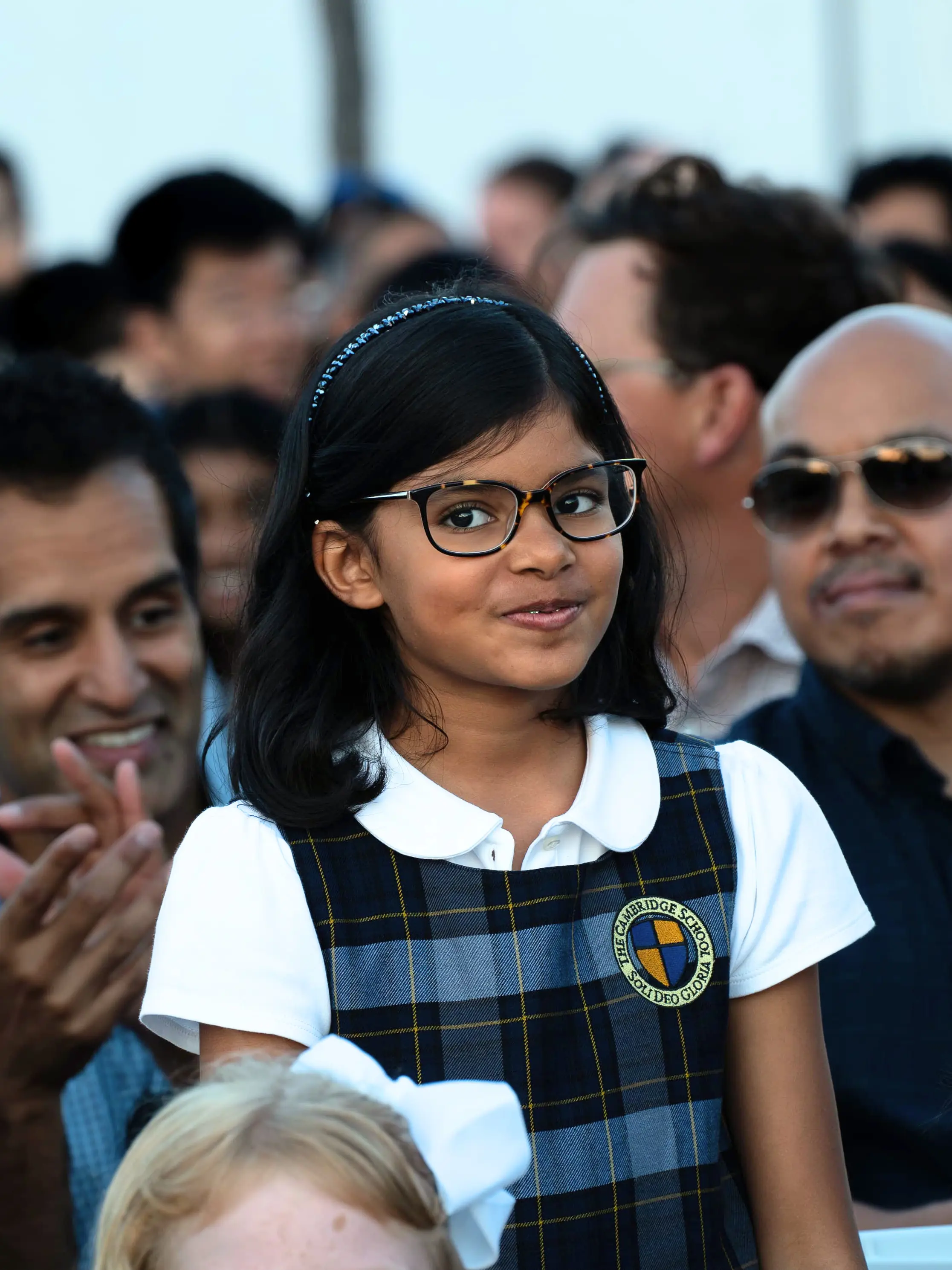 A elementary school student at The Cambridge School, the number one k-12 school in San Diego, stands in recognition at an all school event.